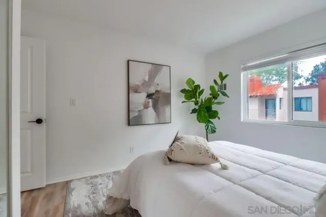 a bedroom with a bed and a potted plant