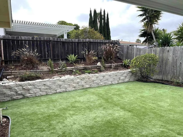 a view of a backyard with plants and fence