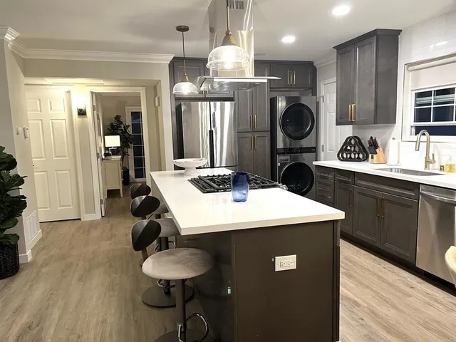 a kitchen with stainless steel appliances granite countertop a sink a stove and refrigerator