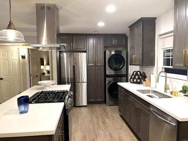 a kitchen with kitchen island granite countertop a sink stove and refrigerator