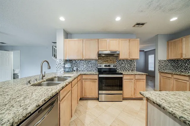 a kitchen with granite countertop cabinets and steel stainless steel appliances