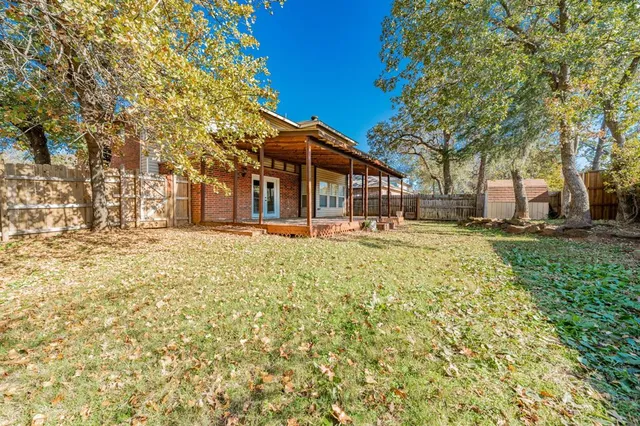 a view of a backyard with table and chairs and wooden fence