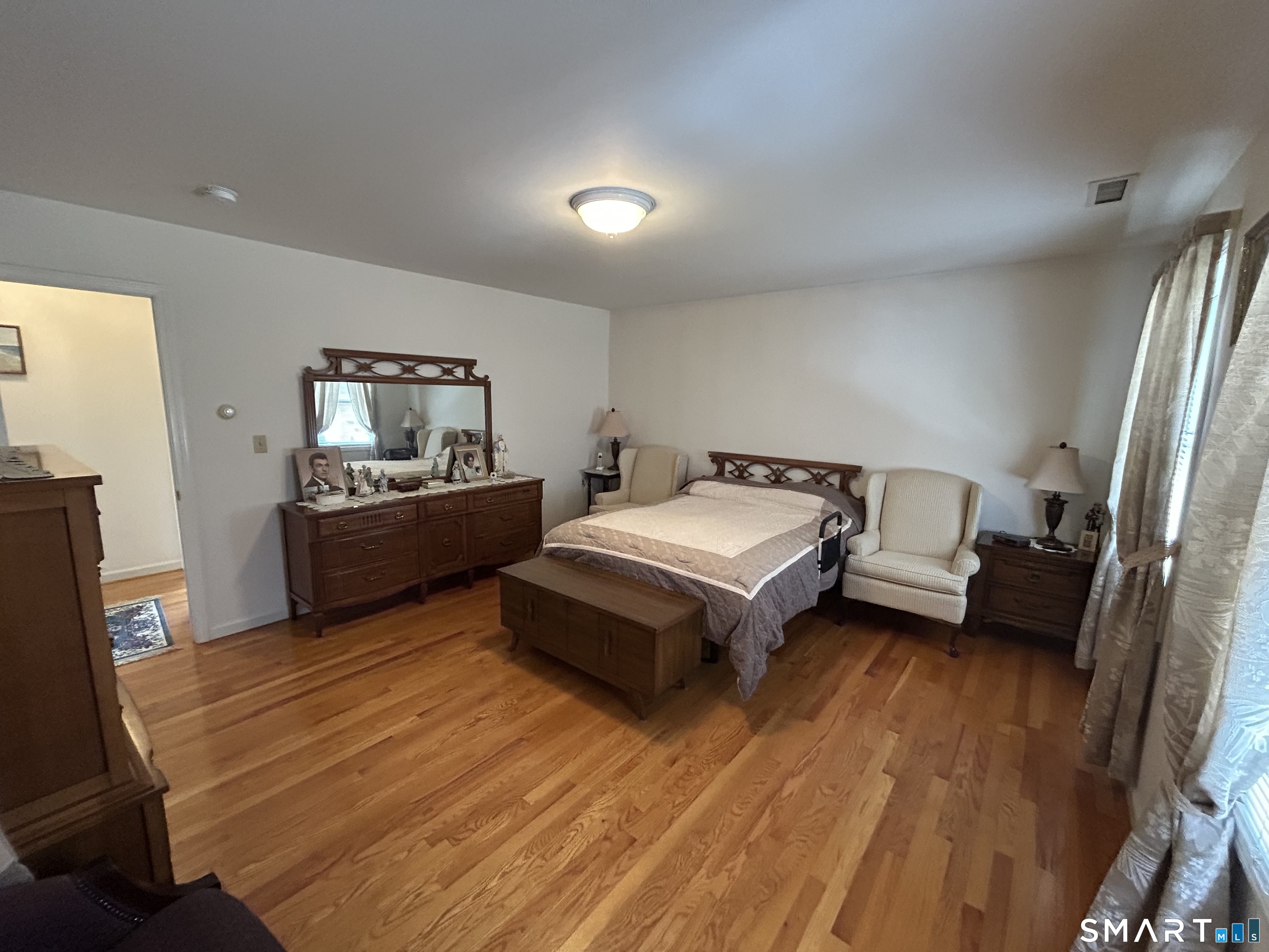 720 Circular Avenue Hamden, CT 06514 - Photo 19 of 35 a spacious bedroom with a bed and a flat tv screen on a dresser