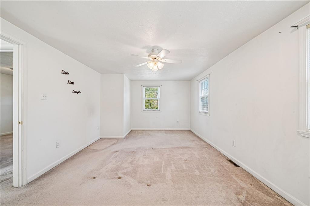 1813 Service Lane Monessen, PA 15062 - Photo 21 of 31 an empty room with windows and a ceiling fan