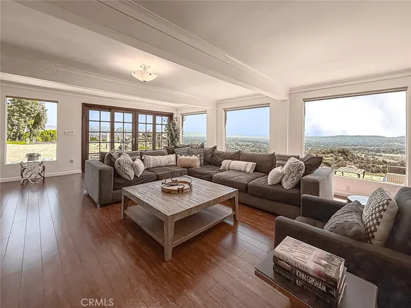 a living room with furniture wooden floor and a large window