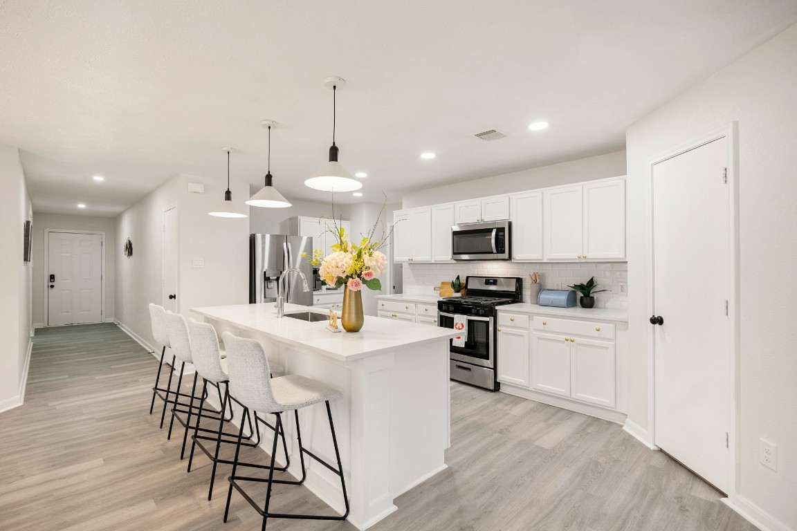 1010 Hummingbird Point Lane Houston, TX 77090 - Photo 5 of 26 Upgraded kitchen featuring quartz countertops, center island, and brand-new appliances.