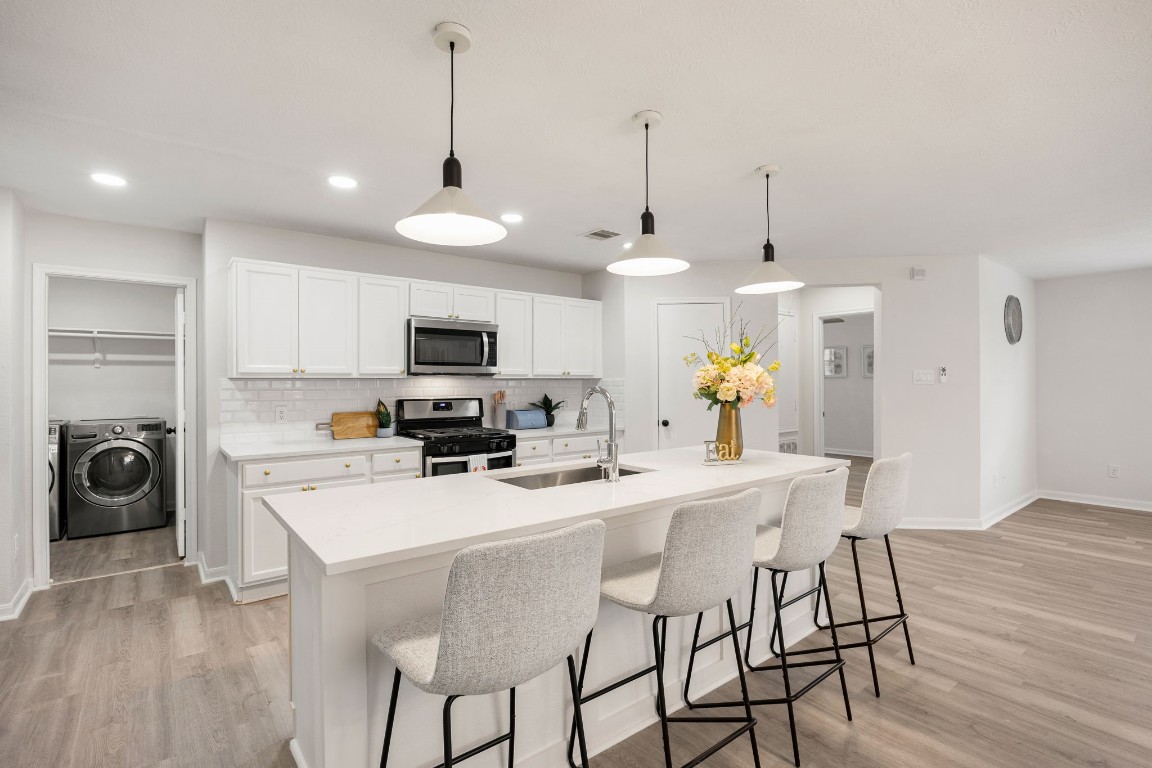 1010 Hummingbird Point Lane Houston, TX 77090 - Photo 7 of 26 Modern kitchen design with sleek backsplash and ample cabinetry for storage.