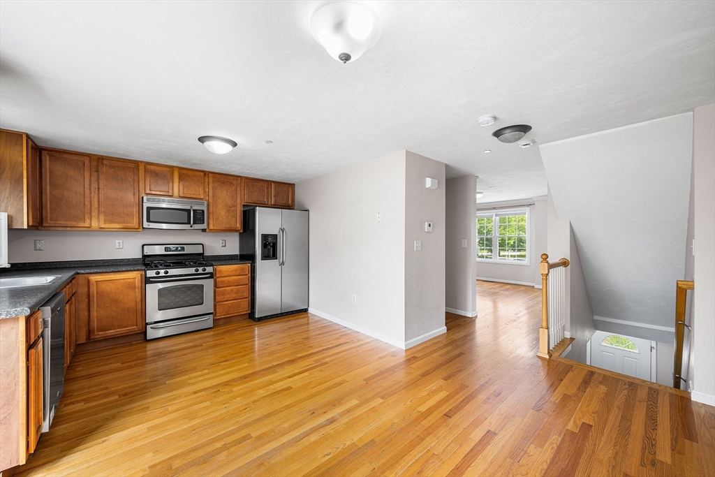 41 Boston Road, Unit 234 Billerica, MA 01862 - Photo 3 of 18 a kitchen with granite countertop a refrigerator and a stove top oven