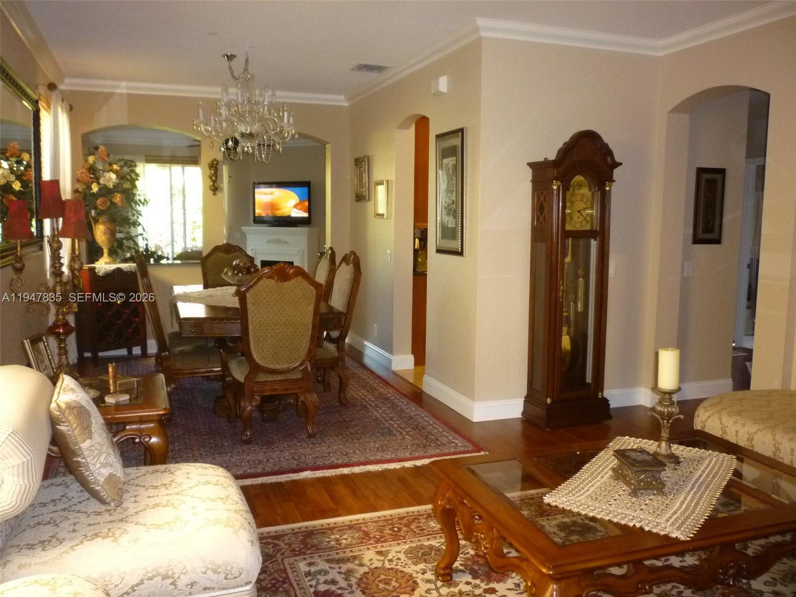644 Conservation Drive Weston, FL 33327 - Photo 2 of 24 a living room with furniture and a chandelier