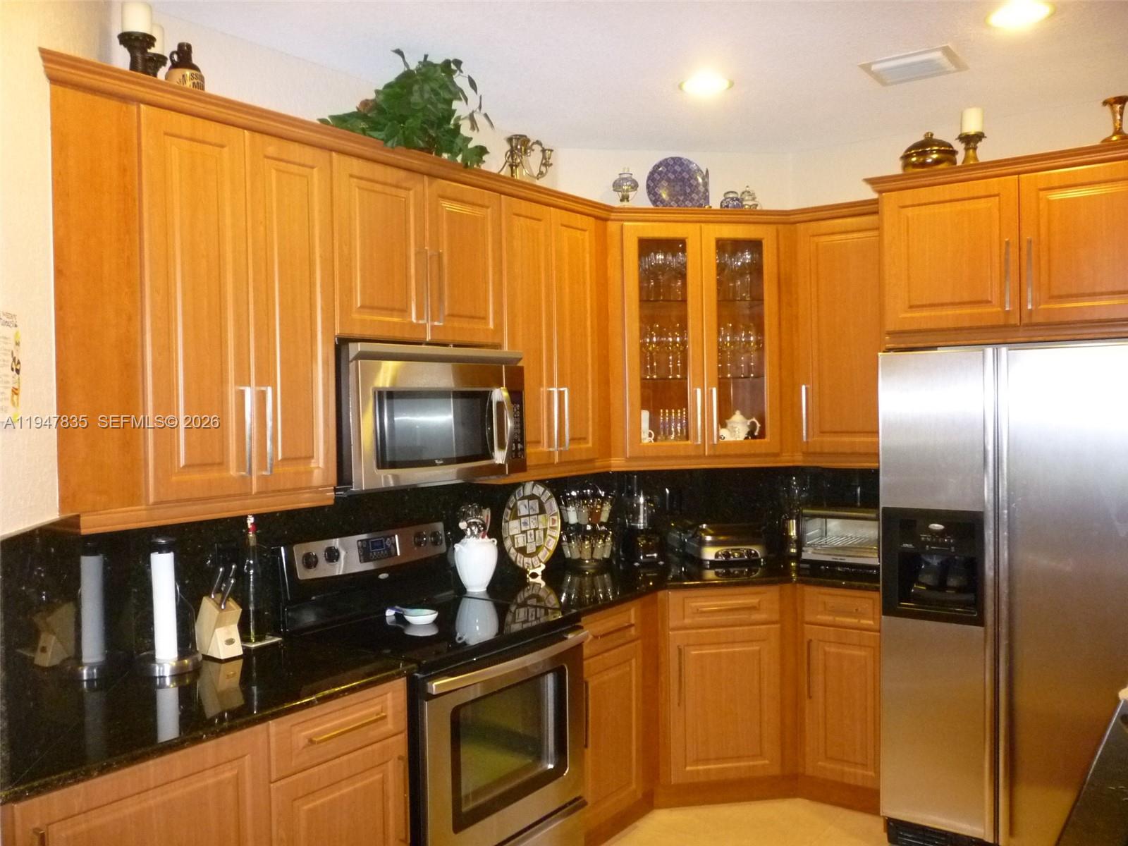 644 Conservation Drive Weston, FL 33327 - Photo 9 of 24 a kitchen with stainless steel appliances granite countertop a refrigerator a stove and a microwave