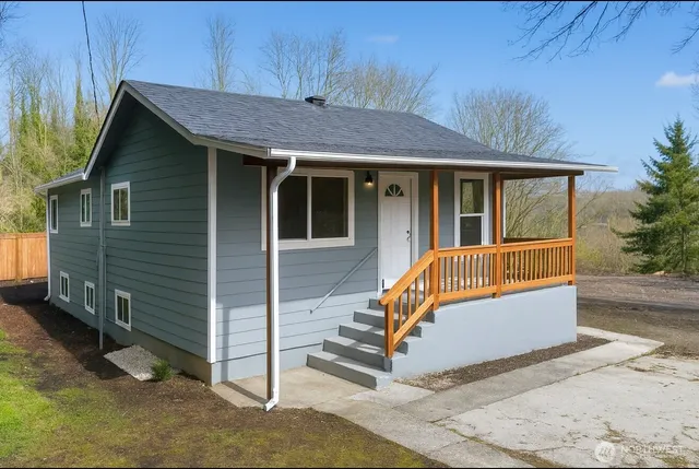 a view of a house with a yard and wooden fence