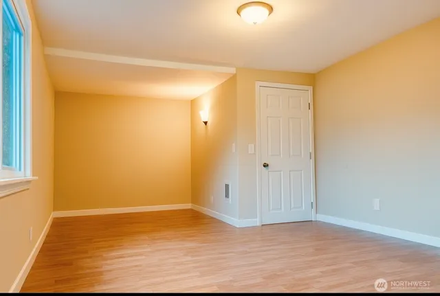 a view of an empty room with wooden floor