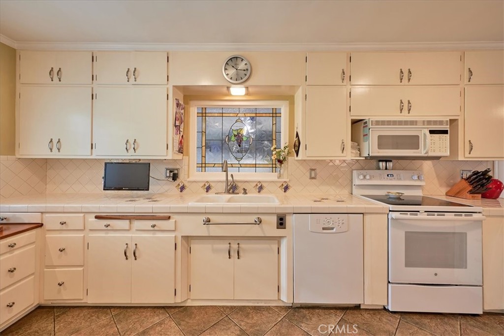 2221 Elsinore Road Riverside, CA 92506 - Photo 18 of 65 a kitchen with white cabinets white stainless steel appliances and sink