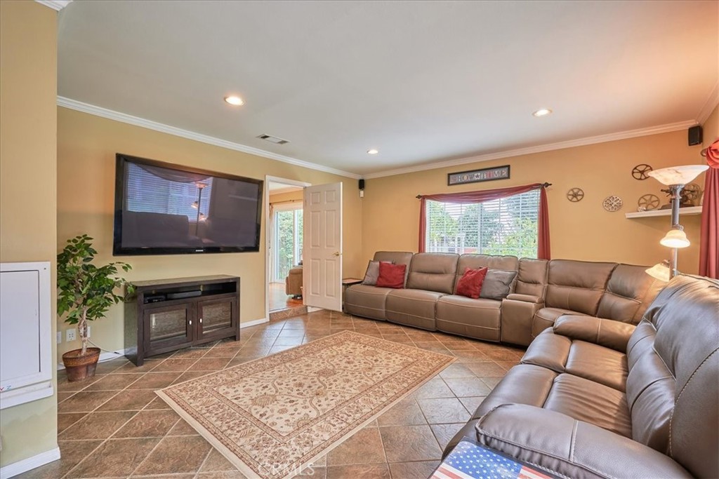 2221 Elsinore Road Riverside, CA 92506 - Photo 24 of 65 a living room with furniture a flat screen tv and a fireplace