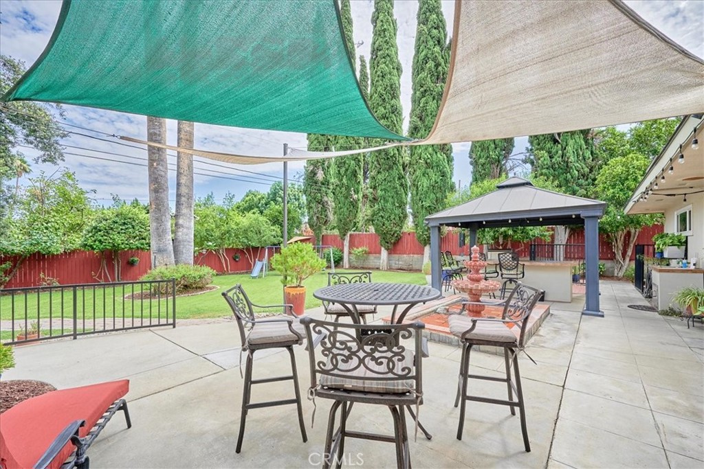 2221 Elsinore Road Riverside, CA 92506 - Photo 45 of 65 a patio with a table and chairs and a barbeque