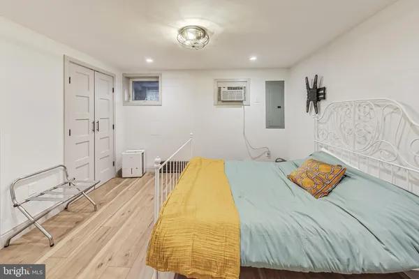 a bedroom with a bed and wooden floor