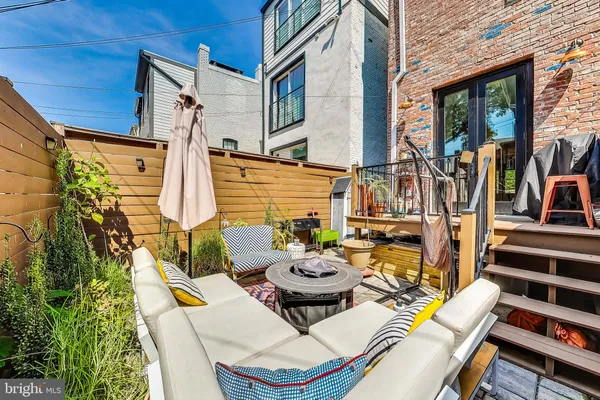 a view of a patio with couches chairs and wooden floor
