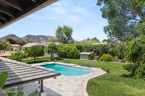 a view of a swimming pool with a yard and plants