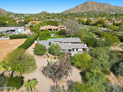 an aerial view of residential houses with outdoor space and trees