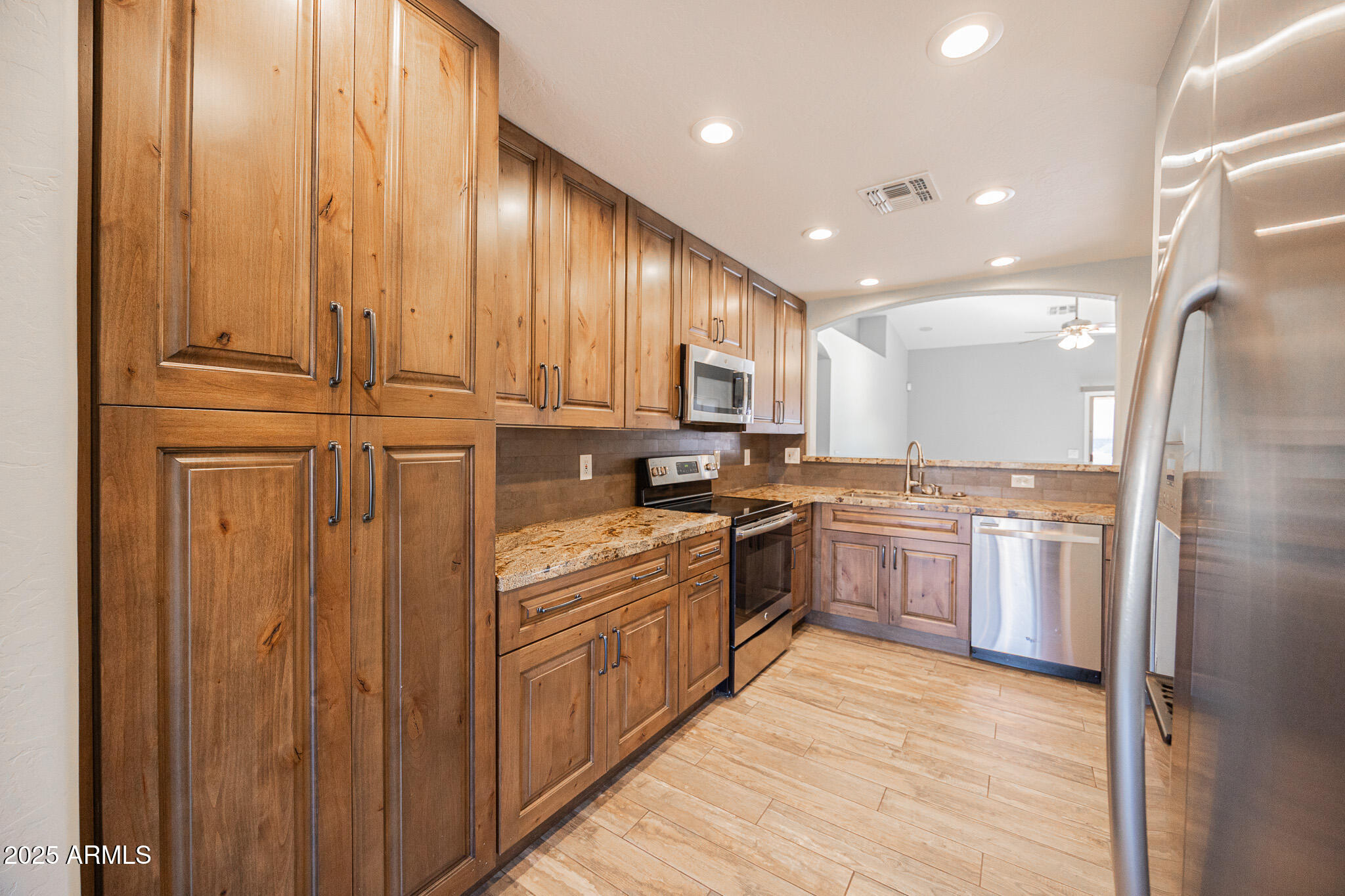 1633 East Beautiful Lane Phoenix, AZ 85042 - Photo 11 of 27 a kitchen with stainless steel appliances granite countertop a refrigerator a sink dishwasher and wooden cabinets with wooden floor
