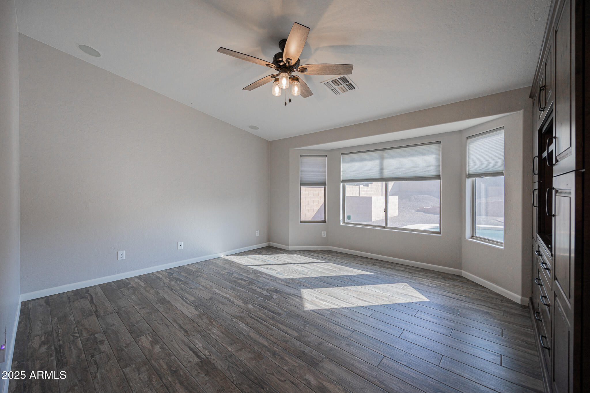 1633 East Beautiful Lane Phoenix, AZ 85042 - Photo 12 of 27 a view of an empty room with a window and wooden floor