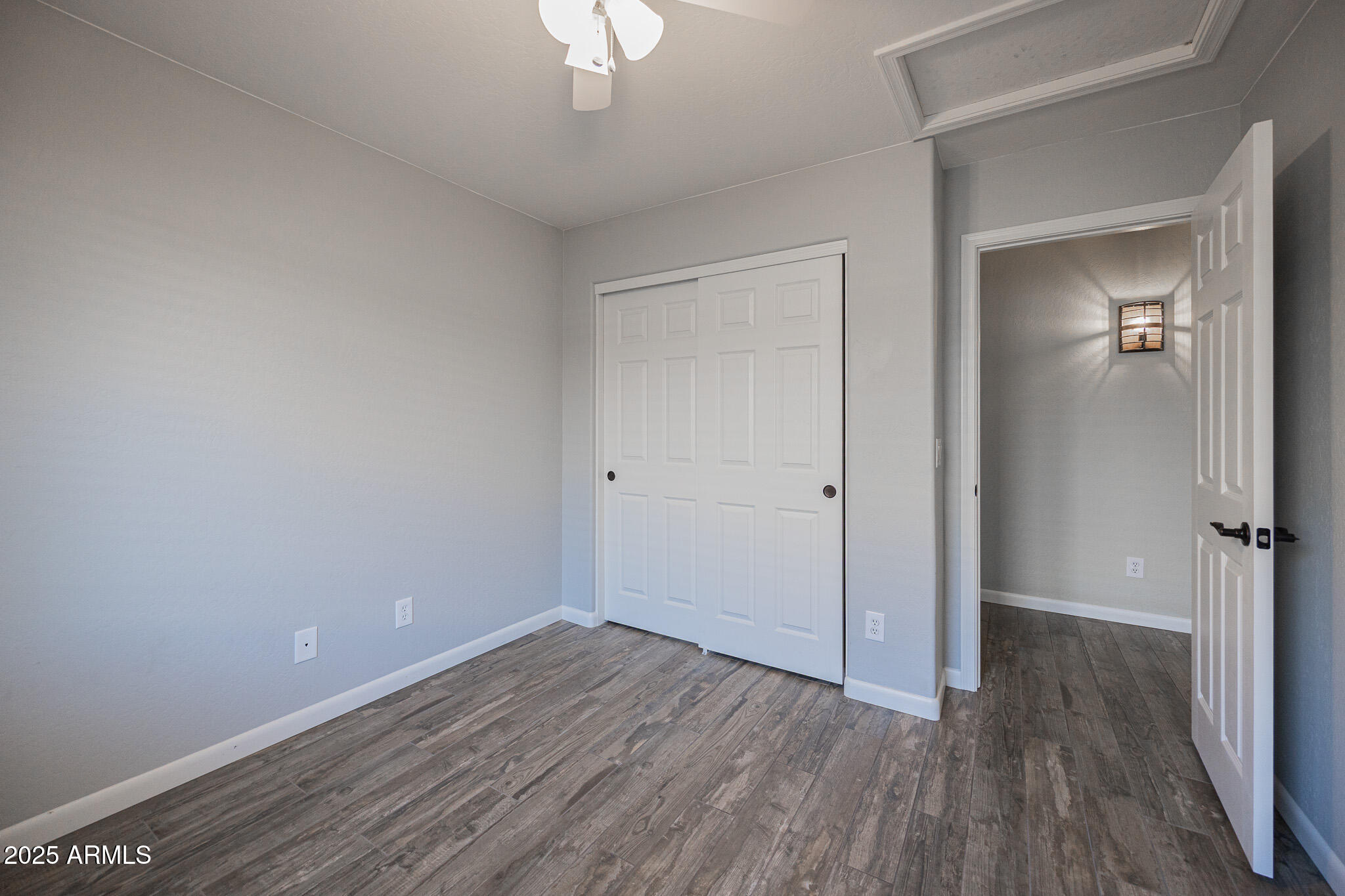 1633 East Beautiful Lane Phoenix, AZ 85042 - Photo 19 of 27 an empty room with wooden floor and mirror