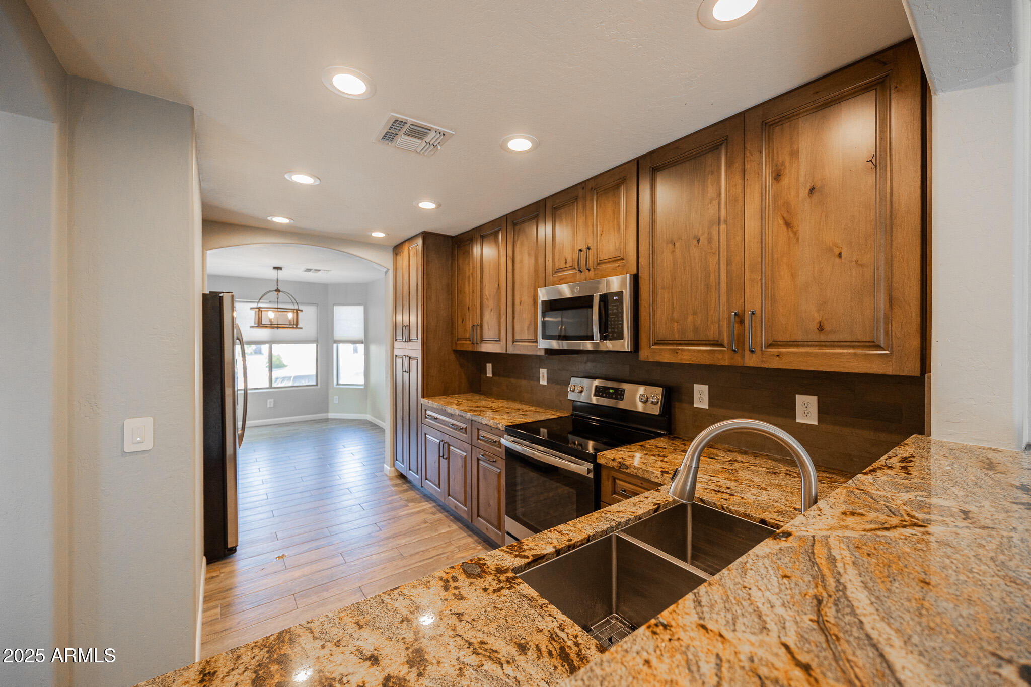 1633 East Beautiful Lane Phoenix, AZ 85042 - Photo 8 of 27 a kitchen with stainless steel appliances granite countertop a stove a sink and a microwave