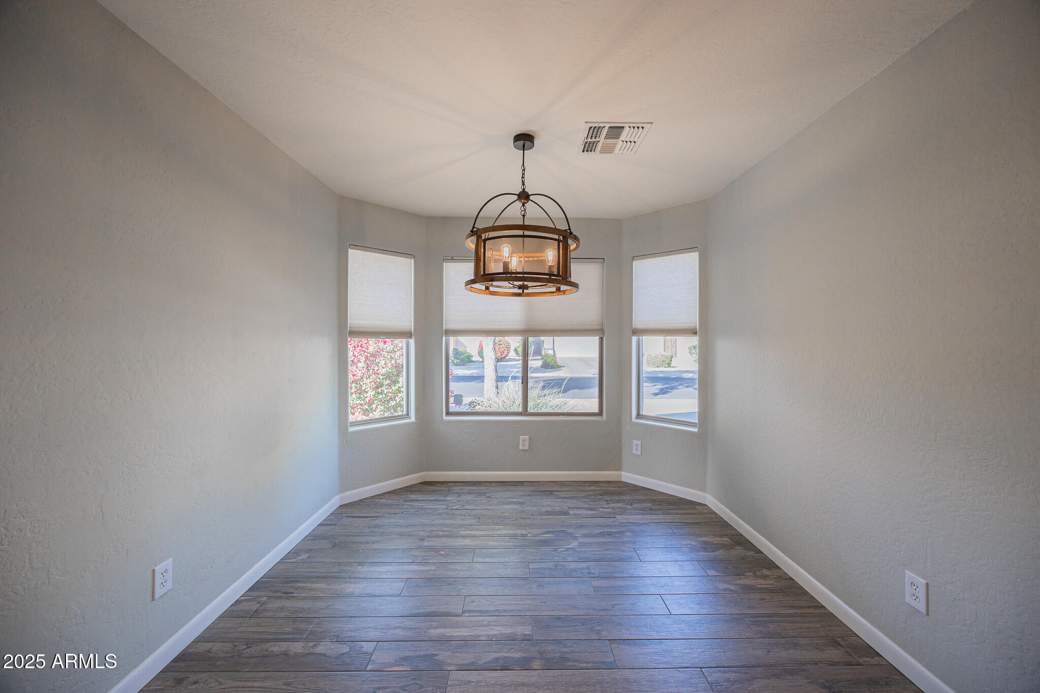 1633 East Beautiful Lane Phoenix, AZ 85042 - Photo 9 of 27 a view of empty room with wooden floor fan and window