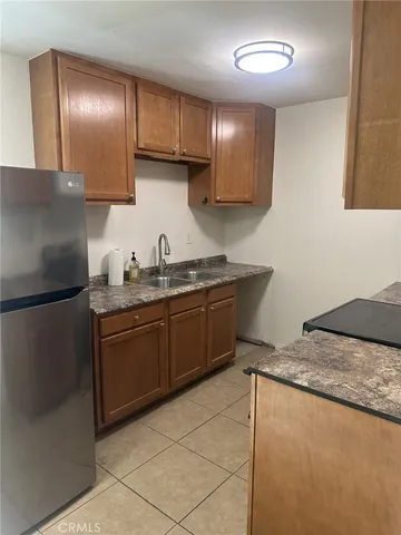 a kitchen with a sink refrigerator and cabinets