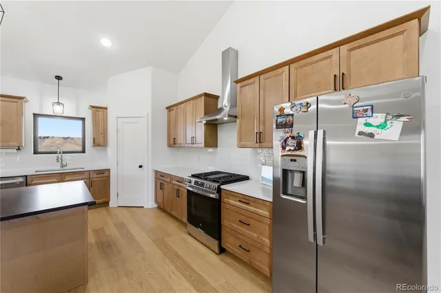 a kitchen with stainless steel appliances granite countertop white cabinets and a stove top oven