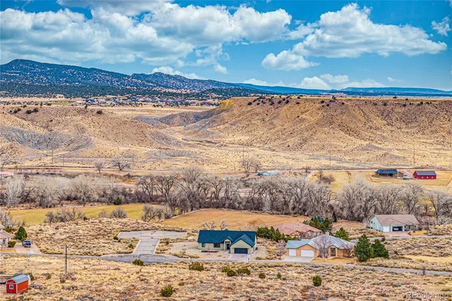a living room with furniture and kitchen view with wooden floor