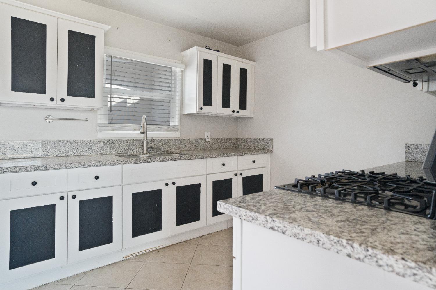 1900 Easy Street Hanford, CA 93230 - Photo 14 of 23 a kitchen with granite countertop a sink stove and cabinets