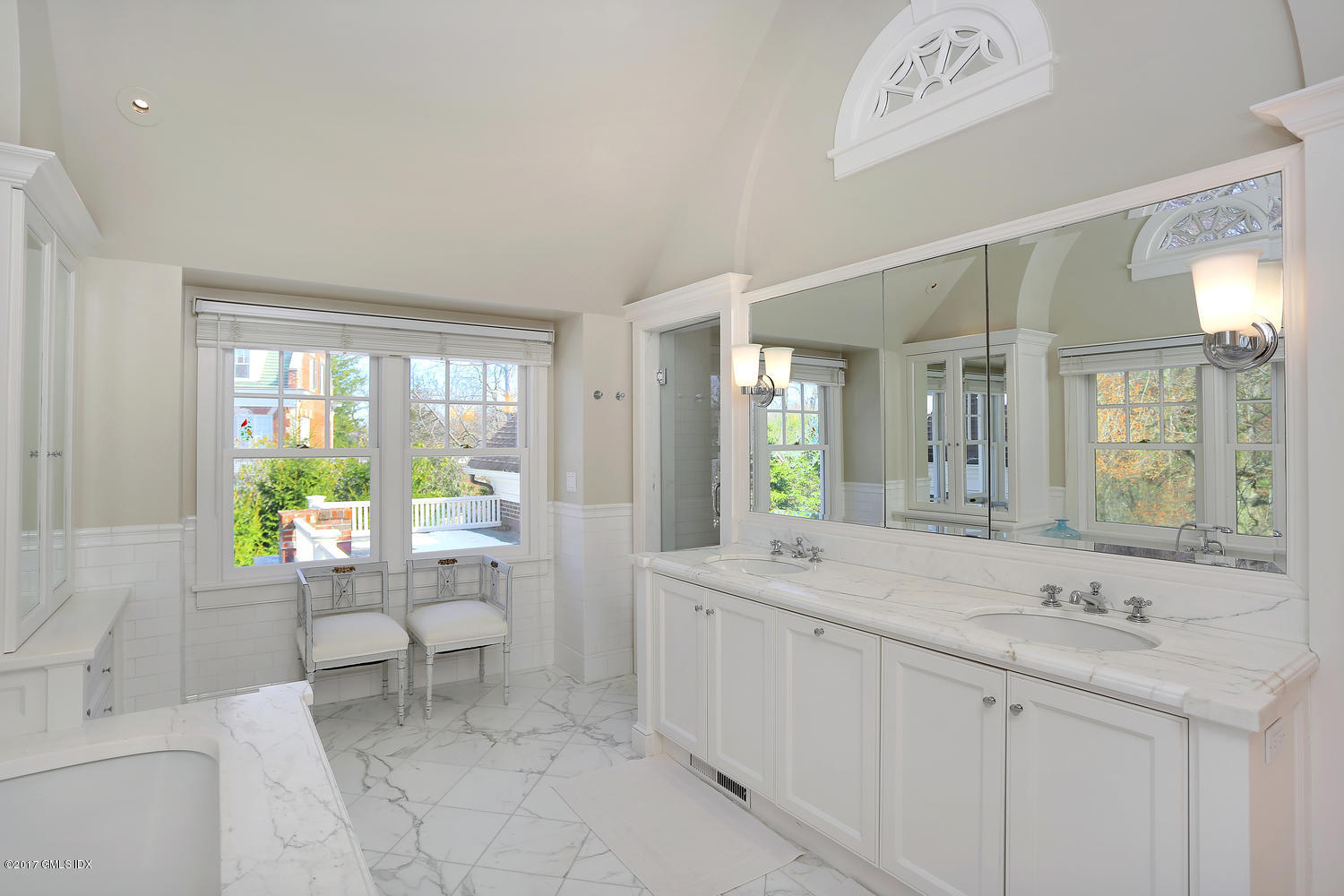 49 Calhoun Drive Greenwich, CT 06831 - Photo 12 of 21 a spacious bathroom with a double vanity sink large mirror and a bathtub
