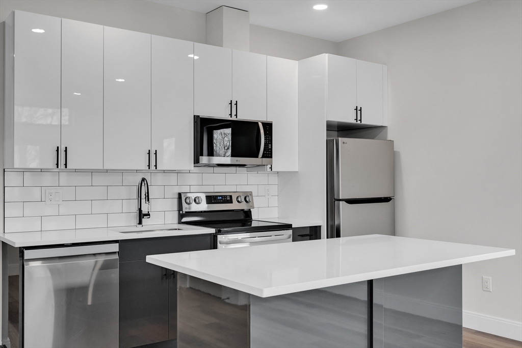 a kitchen with stainless steel appliances a microwave sink refrigerator and cabinets