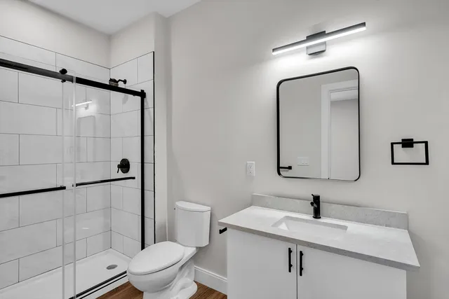 a bathroom with a granite countertop sink toilet and shower