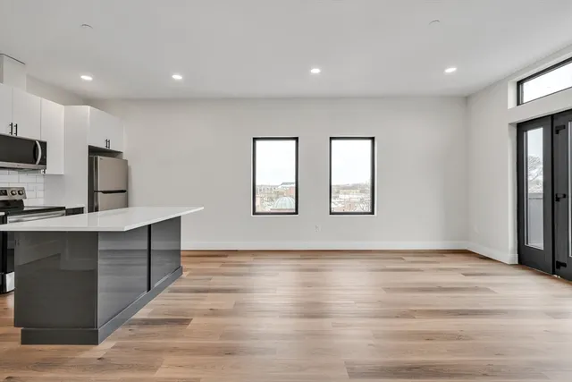 a view of kitchen with wooden floor electronic appliances and window