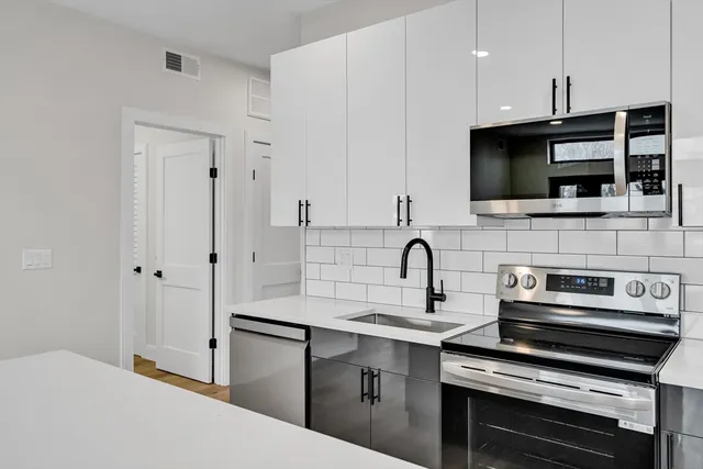 a kitchen with stainless steel appliances a stove sink and microwave