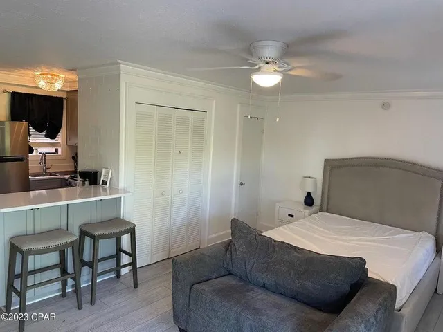 a bedroom with a large bed and a chandelier