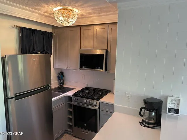 a kitchen with a refrigerator and a stove top oven