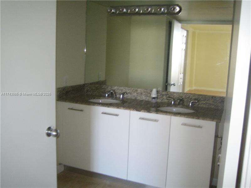 3300 Northeast 191st Street, Unit 1708 Aventura, FL 33180 - Photo 2 of 7 a bathroom with a granite countertop sink and a mirror