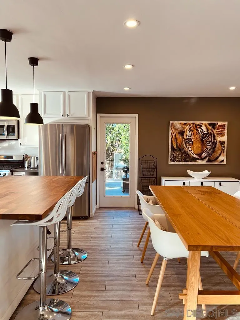 5560 Diane Avenue San Diego, CA 92117 - Photo 15 of 31 a dining room with wooden floor a glass table and chairs