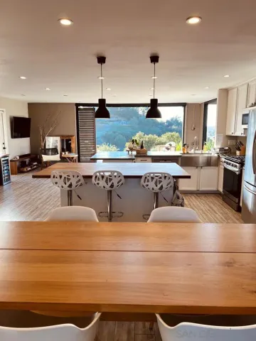 a living room with stainless steel appliances granite countertop furniture and fireplace