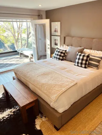 a bedroom with a bed and a large window