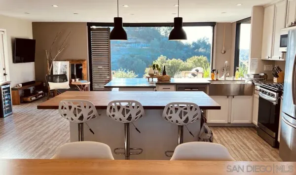 a kitchen with stainless steel appliances granite countertop a stove and a wooden floor