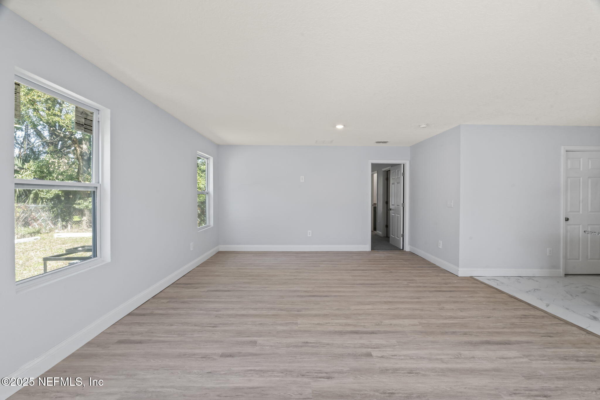9332 Sisson Drive Jacksonville, FL 32218 - Photo 21 of 42 a view of an empty room with wooden floor and a window