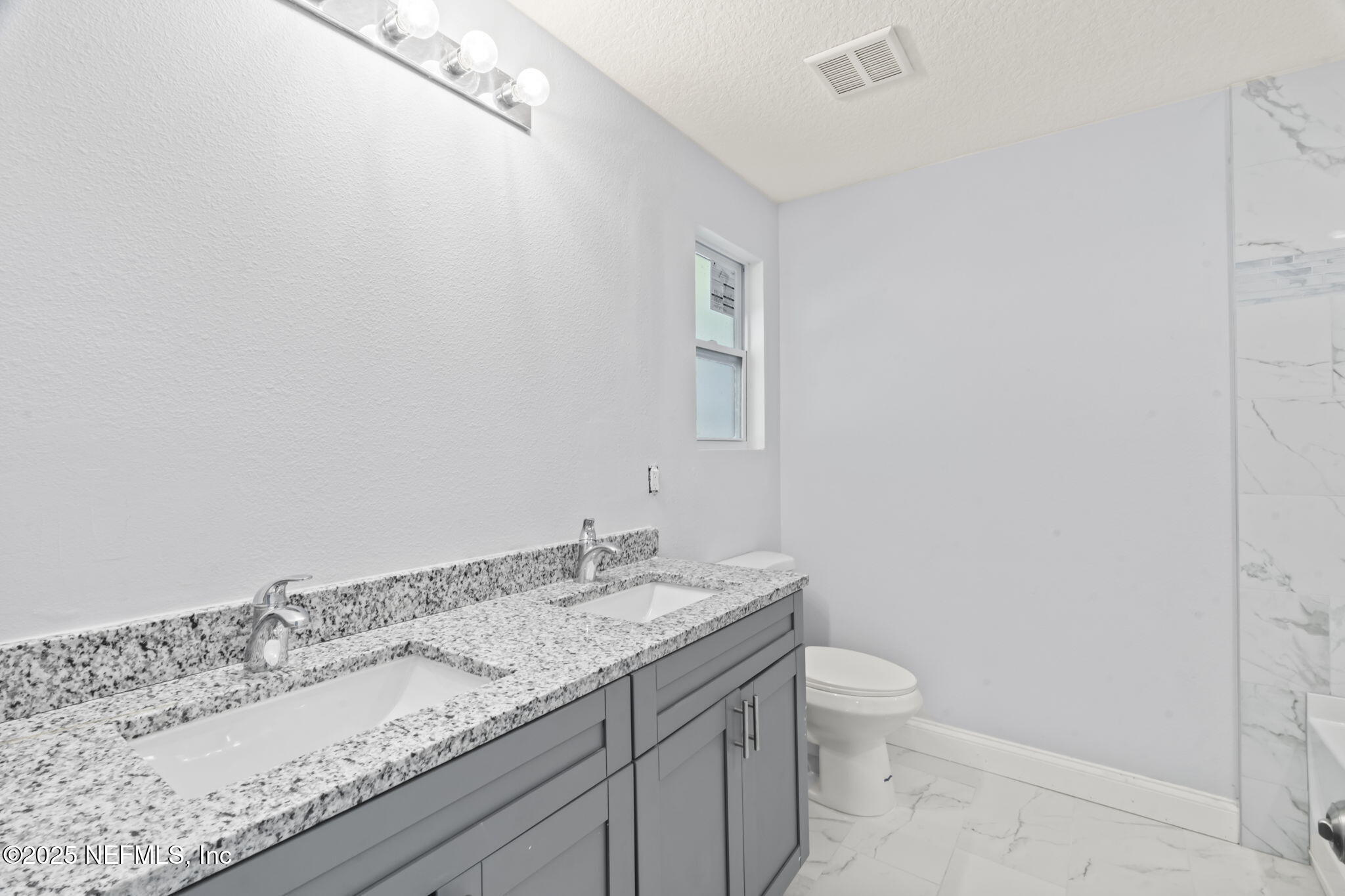 9332 Sisson Drive Jacksonville, FL 32218 - Photo 26 of 42 a bathroom with a granite countertop sink a toilet and a mirror