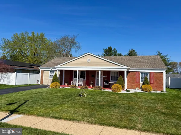 a front view of a house with a yard and trees