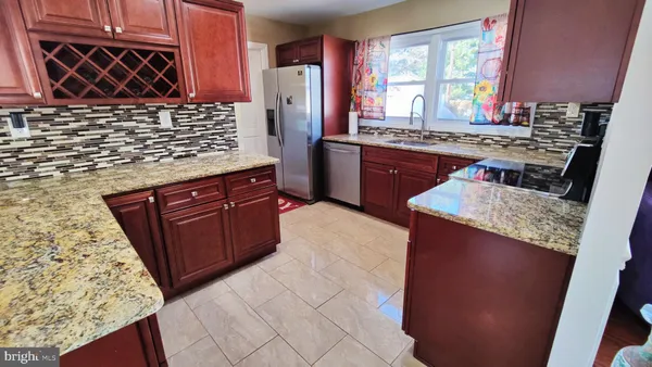 a kitchen with stainless steel appliances granite countertop a stove a refrigerator and a counter space