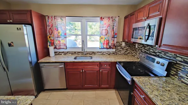 a kitchen with stainless steel appliances granite countertop a refrigerator and a stove
