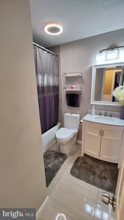 a spacious bathroom with a granite countertop sink a toilet a mirror and shower